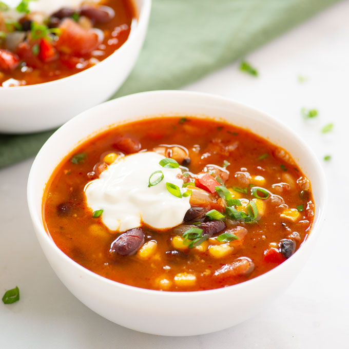 vegan chili topped with dairy-free sour cream and green onions