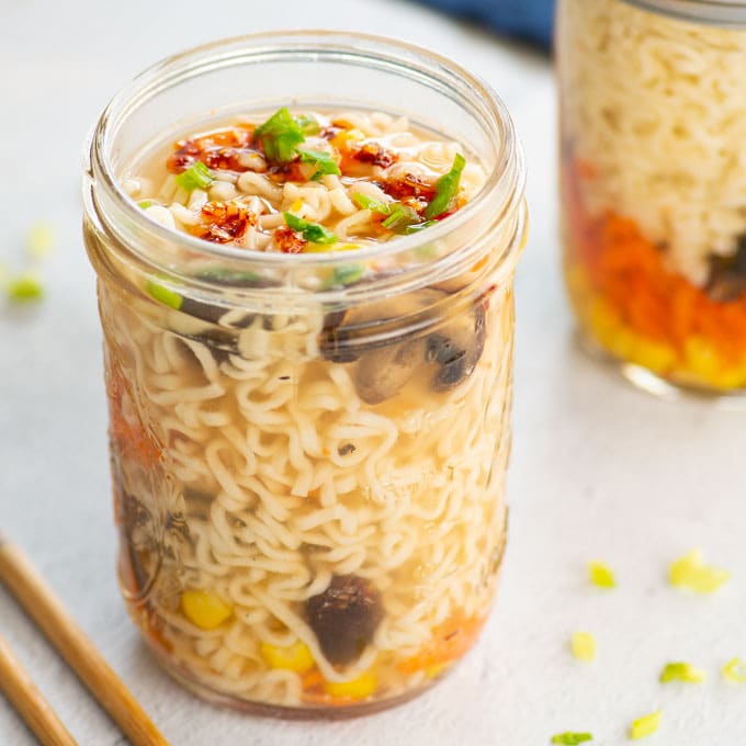 vegan ramen noodles in a mason jar topped with chili oil and green onions
