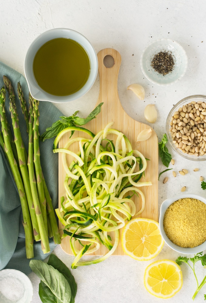 ingredients for zoodles with asparagus and lemon pesto sauce on white background