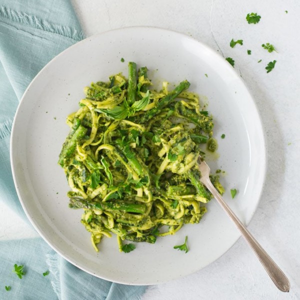 plate of lemon pesto zoodles with asparagus and parsley