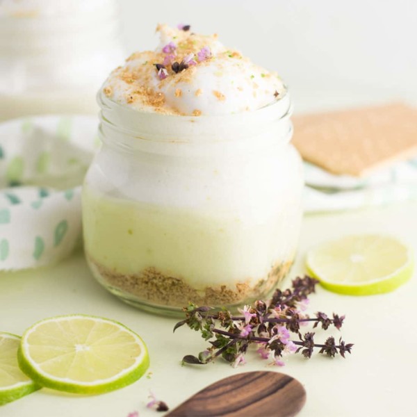 vegan key lime pie parfait with purple flowers and lime wedges