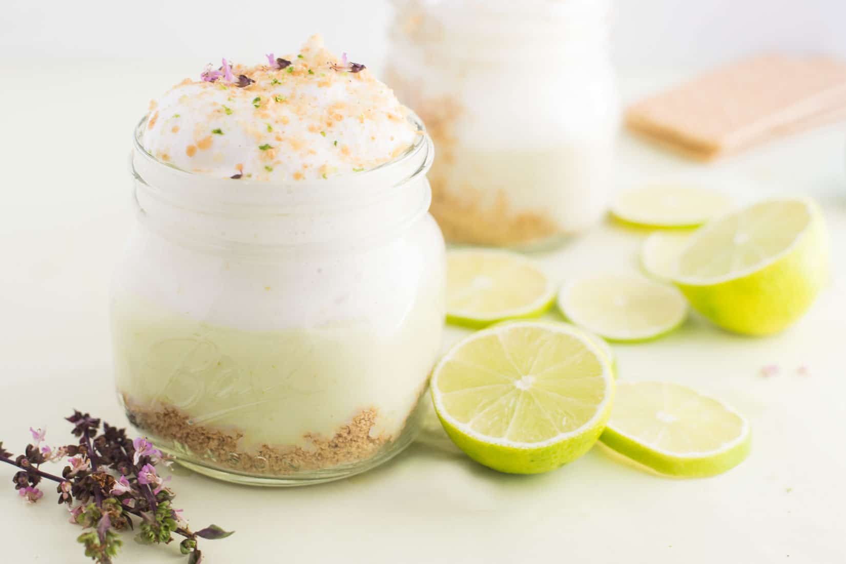 vegan key lime pie parfaits with lime wedges and purple flowers