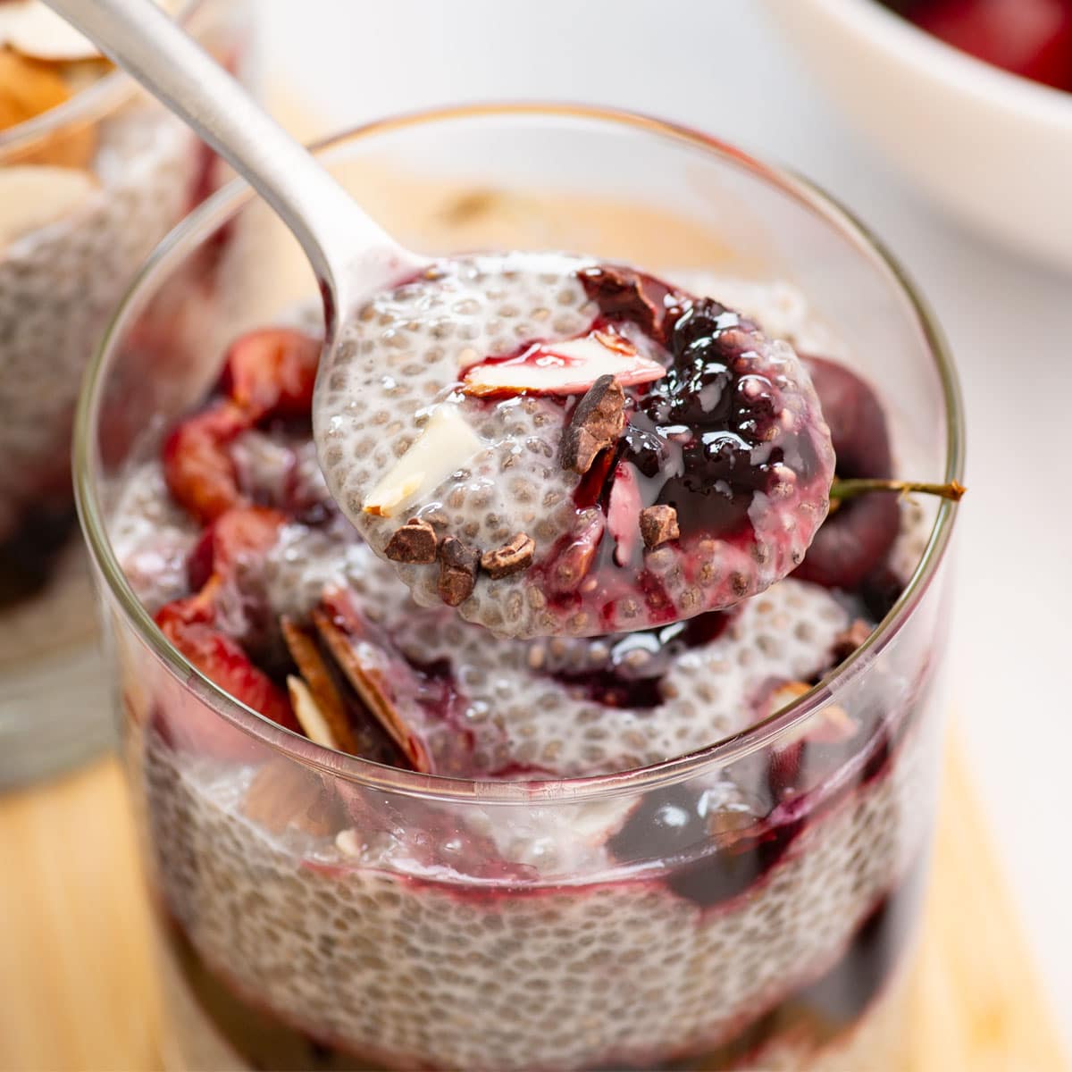spoonful of chia seed pudding, cherry compote, almonds and chocolate sauce
