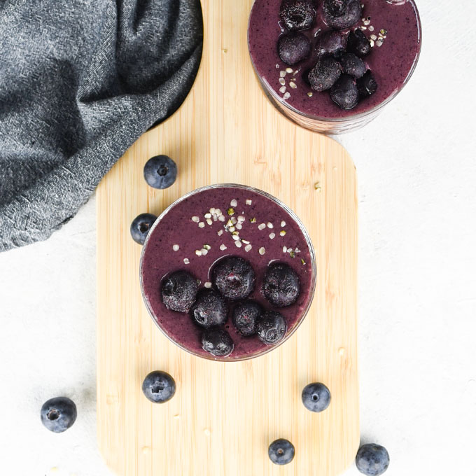 overhead shot of two smoothies topped with blueberries and hemp seeds
