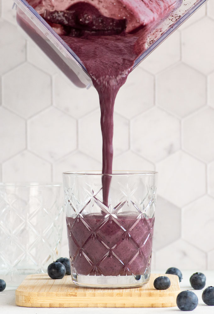 pouring smoothie into a glass
