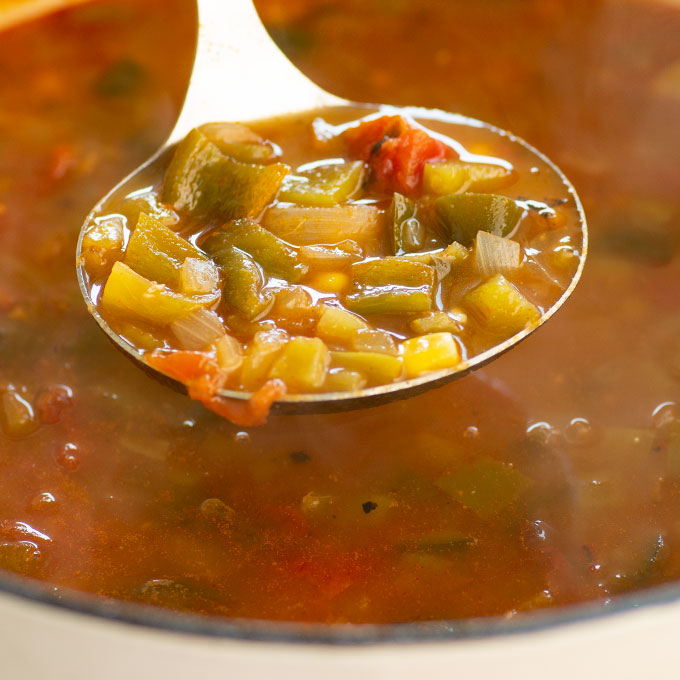 ladle of southwestern soup over dutch oven