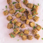 baked and breaded tofu bites on light pink background with parsley