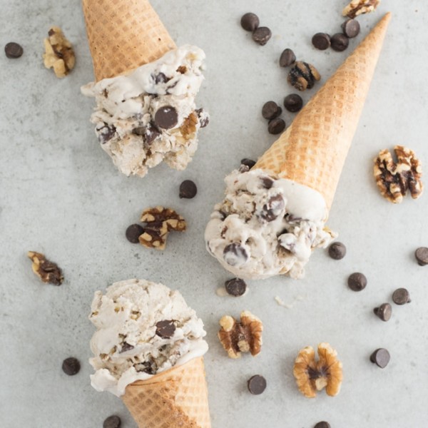 vegan banana nice cream in cones with walnuts and chocolate chips on grey background