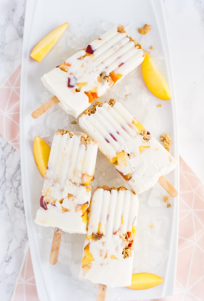 peaches and cream popsicles with peach slices on tray with pink napkin