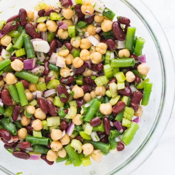 glass bowl full of three bean salad on marble background