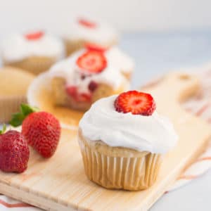 vegan strawberry shortcake cupcake on wooden board with fresh strawberries