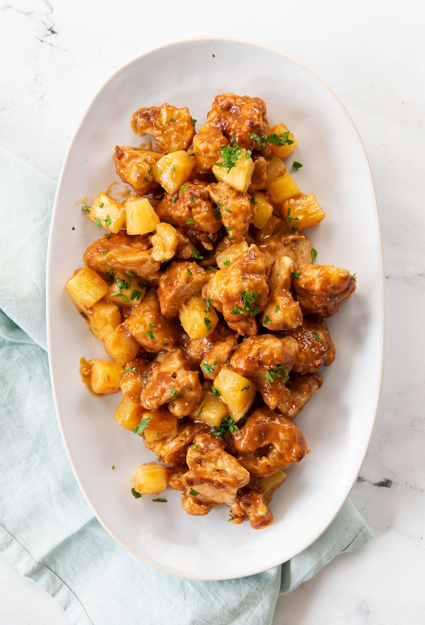 baked cauliflower bites on a platter with pineapple and cilantro