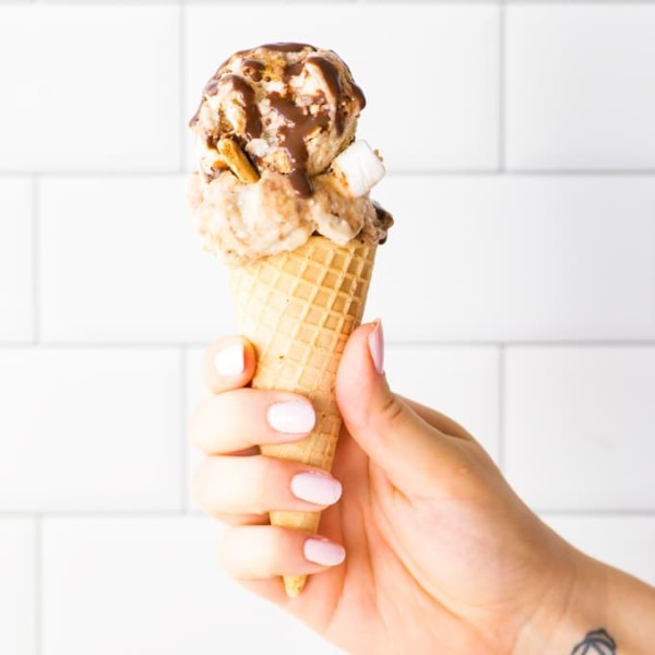 hand holding vegan ice cream cone against white background