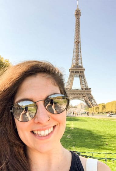 girl with brown hair posing in front of eiffel tower in paris france