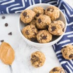 bowl of peanut butter chocolate chip energy bites on marble background with blue napkin