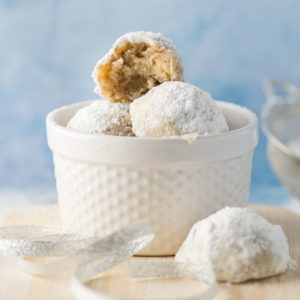 vegan russian tea cakes in white dish on blue background