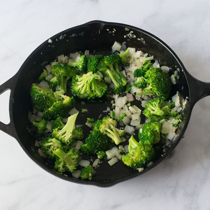 broccoli and onions in cast iron skillet