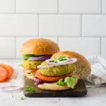 veggie burger with lettuce, tomato, red onion, mayo on bun with white background