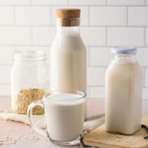 homemade oat milk on pink background