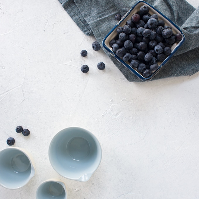 basket of blueberries on light grey background