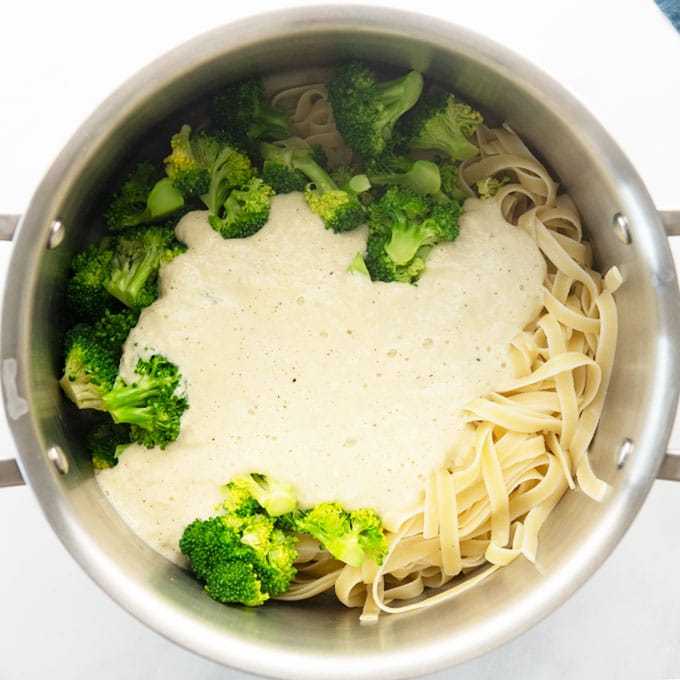 pasta, vegan alfredo sauce, and broccoli in pan