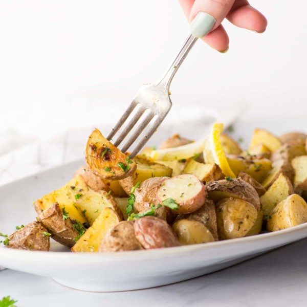 fork holding roasted red potato with lemon and dill