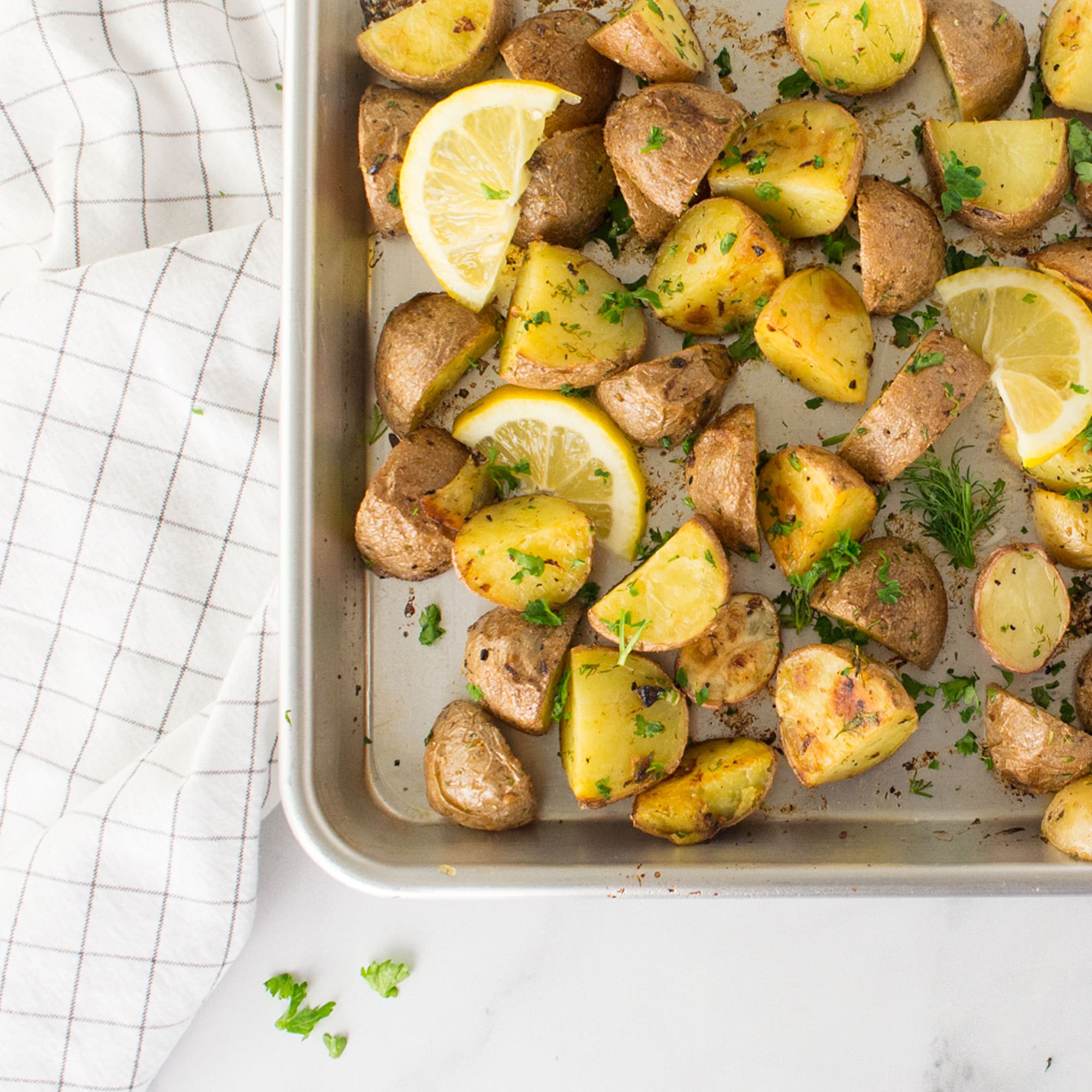 roasted red potatoes on baking sheet with lemon and dill