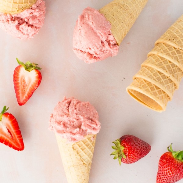 vegan strawberry banana nice cream with ice cream cones and strawberries