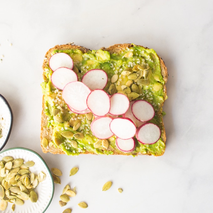 Vegan avocado toast with radishes, hemp seeds, and pepitas