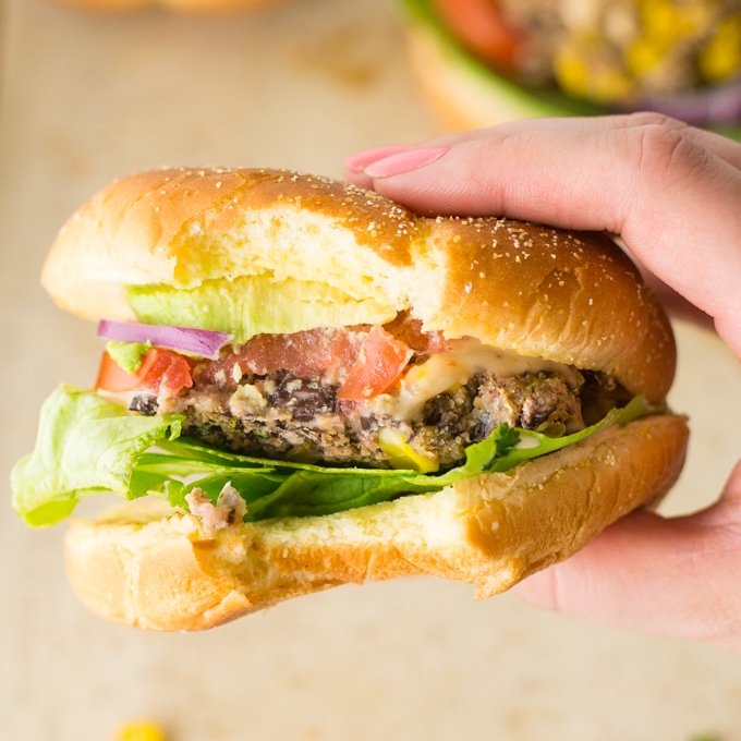 hand holding vegan corn and black bean veggie burger