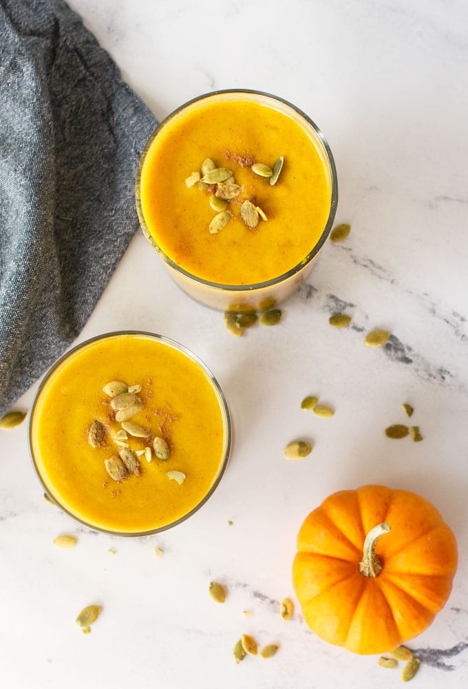 overhead view of two vegan pumpkin smoothies with pumpkin seeds