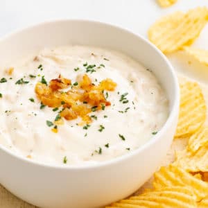 bowl of french onion dip topped with caramelized onions