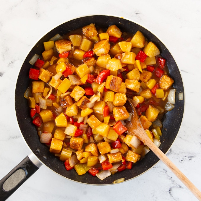 tofu, peppers, onions, pineapple in large pan with sweet and sour sauce