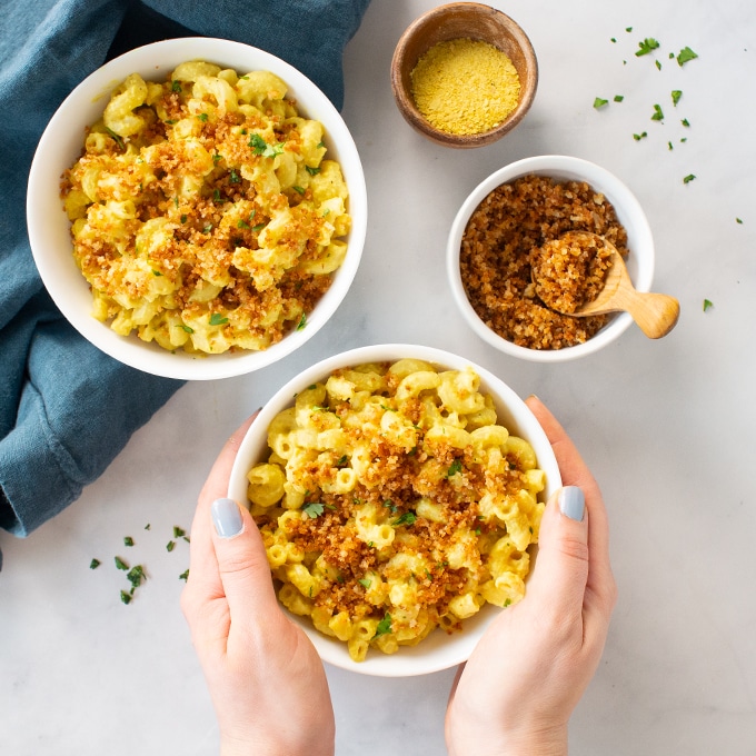 two bowls of vegan mac and cheese with breadcrumbs