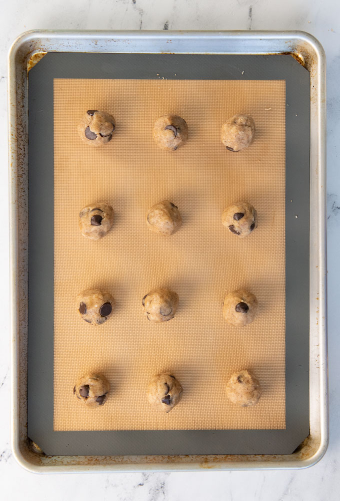 raw chocolate chip cookie dough on baking sheet