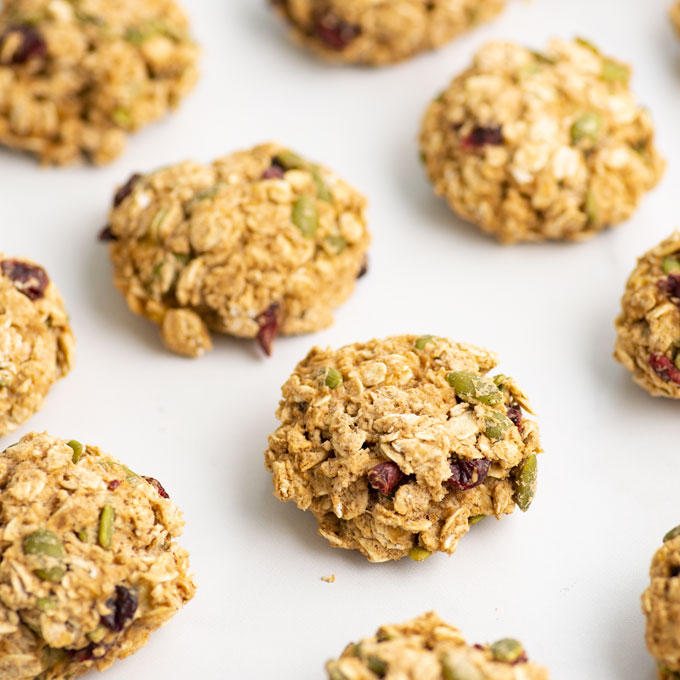 breakfast cookies with dried cranberries and pepitas on white background