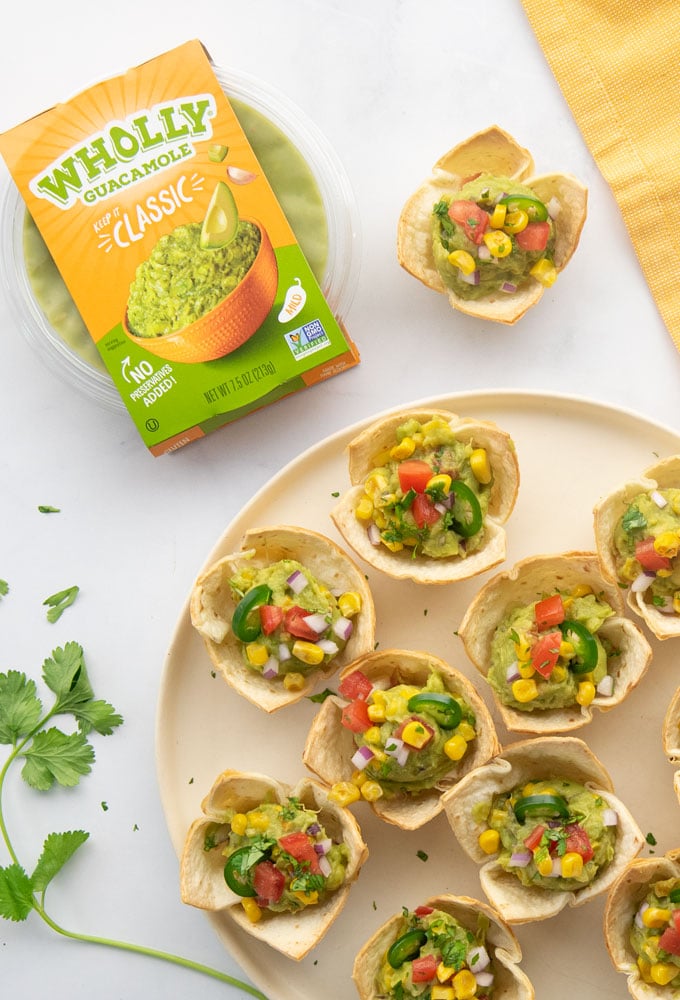 guacamole cups on a plate with wholly guacamole package