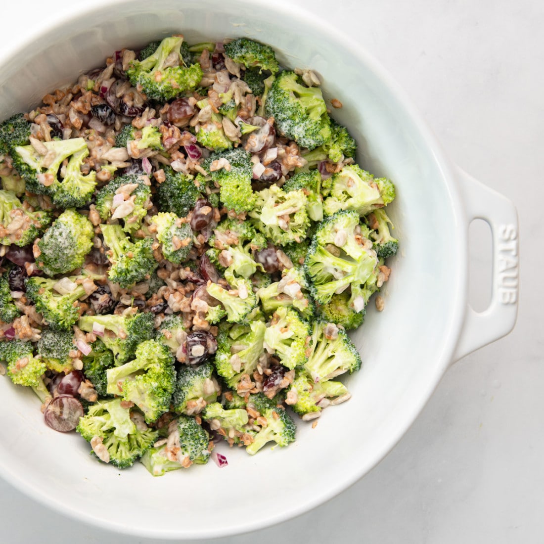 vegan broccoli salad with cranberries, sunflower seeds, grapes, and a creamy dressing