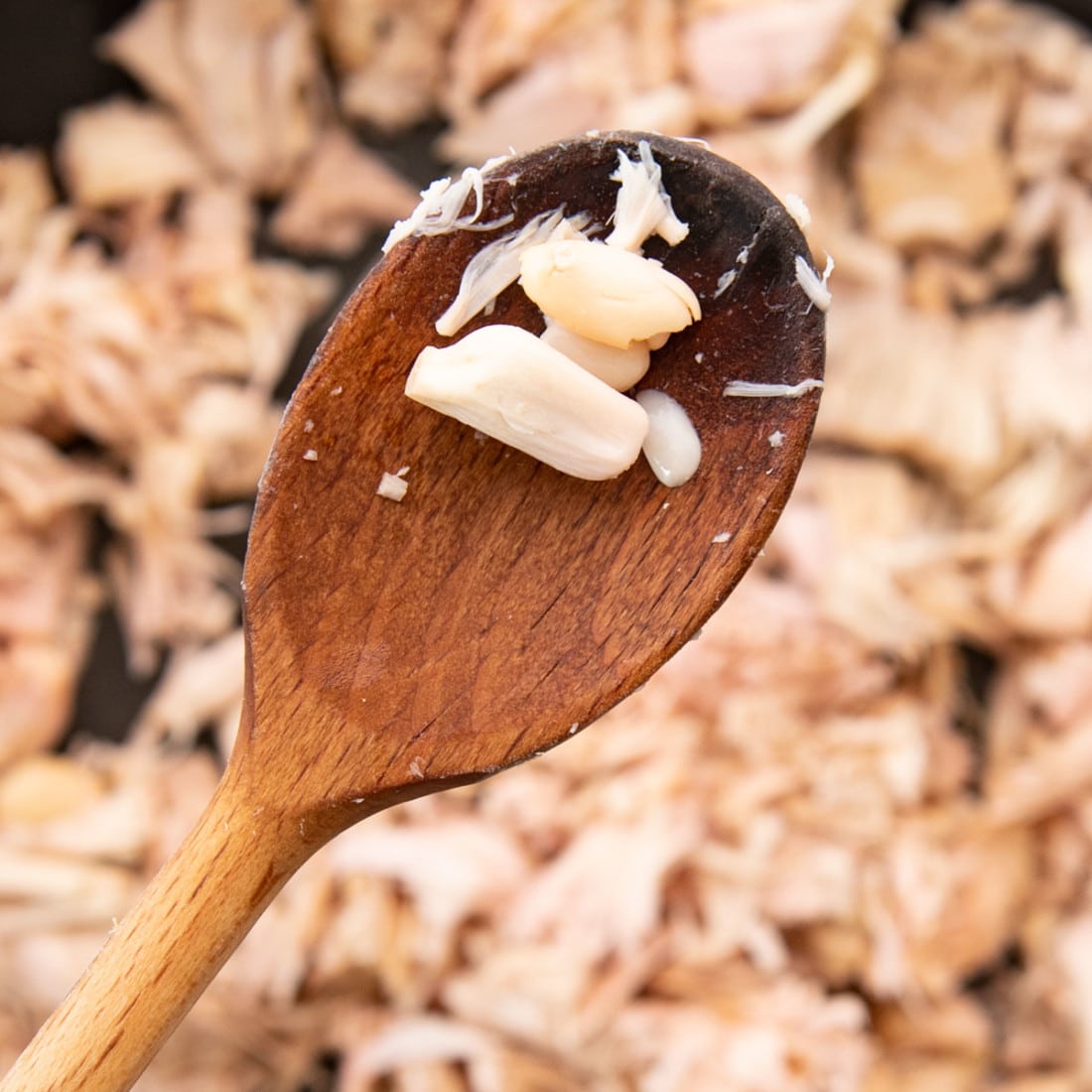 shredded mashed jackfruit on a wooden spoon