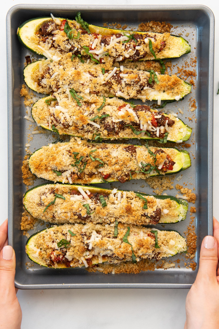 vegan zucchini boats stuffed with meatless meat sauce, veggies, cheese, and breadcrumbs