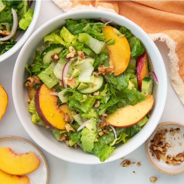 overhead view of salad with peaches and walnuts