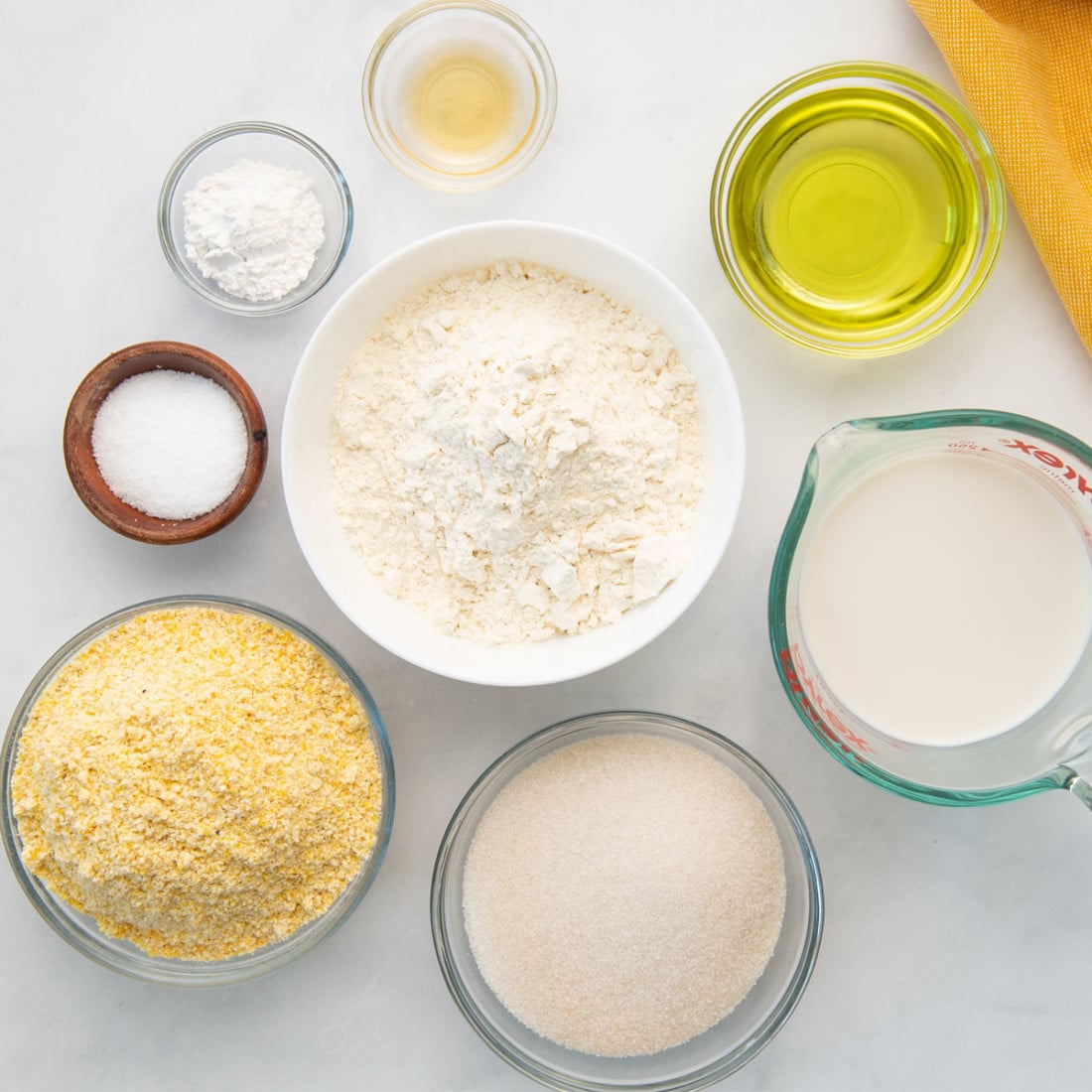overhead top view flour, cornmeal, oat milk, oil, spices, baking powder