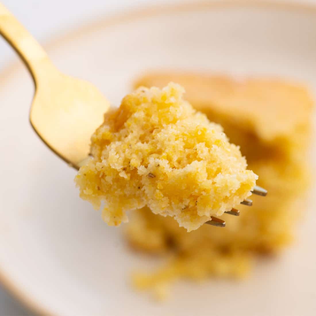 up close view of gold fork with piece of fluffy cornbread